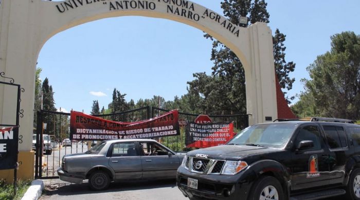 Trabajadores del Sindicato Administrativo de la UAAAN colgaron banderas rojinegras en la puerta principal de la institución. 