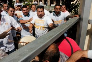 ENFRENTAMIENTO. Cerca de 50 hombres, que vestían playeras blancas con las iniciales del SNTE, no permitieron la entrada a maestros disidentes que buscaban tomar las instalaciones. (Foto: Grisel Pajarito)